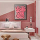 A stylish pink bedroom showcases the Urbanic Pink Welcome Script 3D Wooden Graffiti Wall Art by Giant Sculptures with Welcome to the Circus in bold. The modern setting includes a bed, teddy bear, and nightstand with books, a clock, and decorative items.