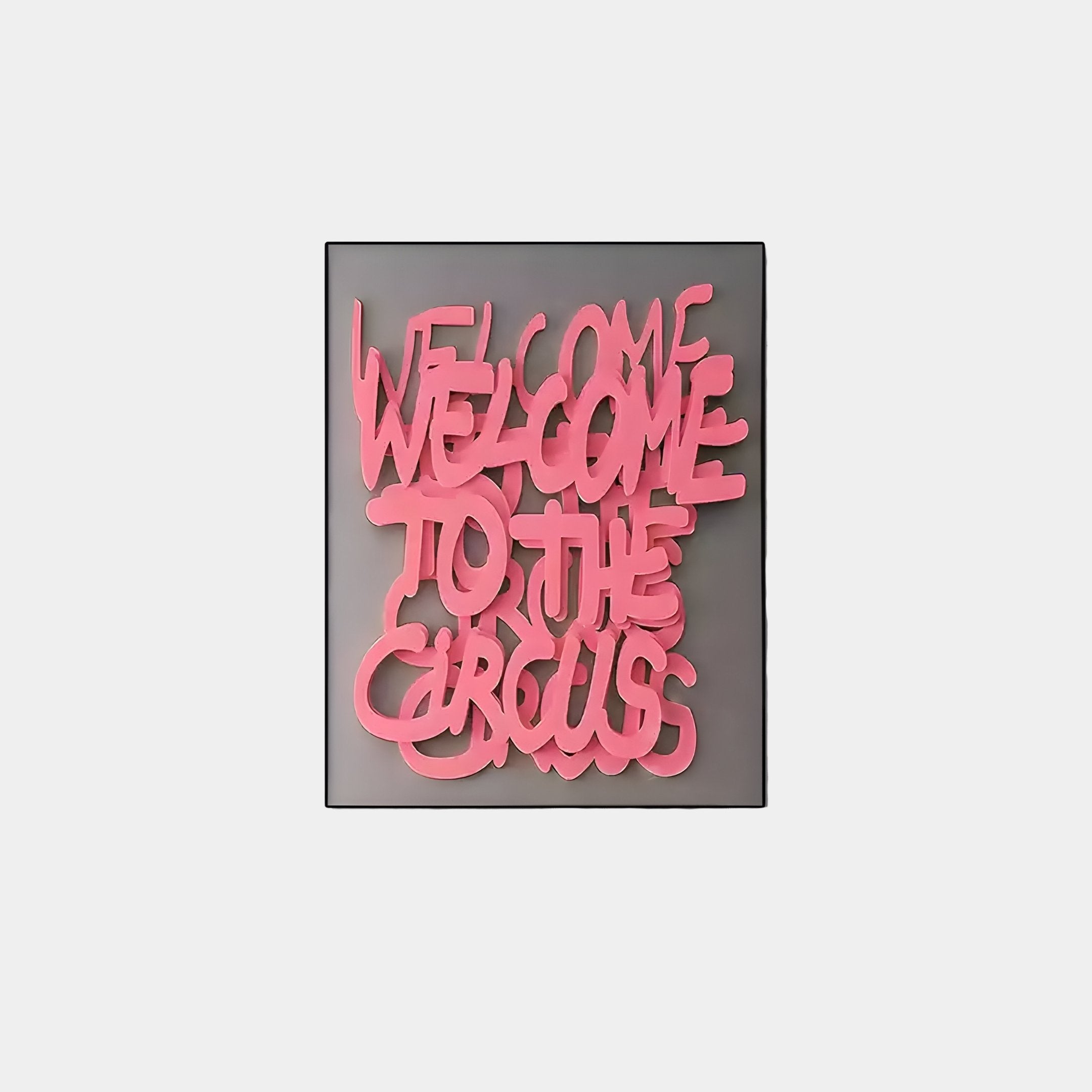 The Urbanic Pink Welcome Script 3D Wooden Graffiti Wall Art by Giant Sculptures features overlapping text, WELCOME TO THE CIRCUS, on a dark gray background for an edgy visual experience.