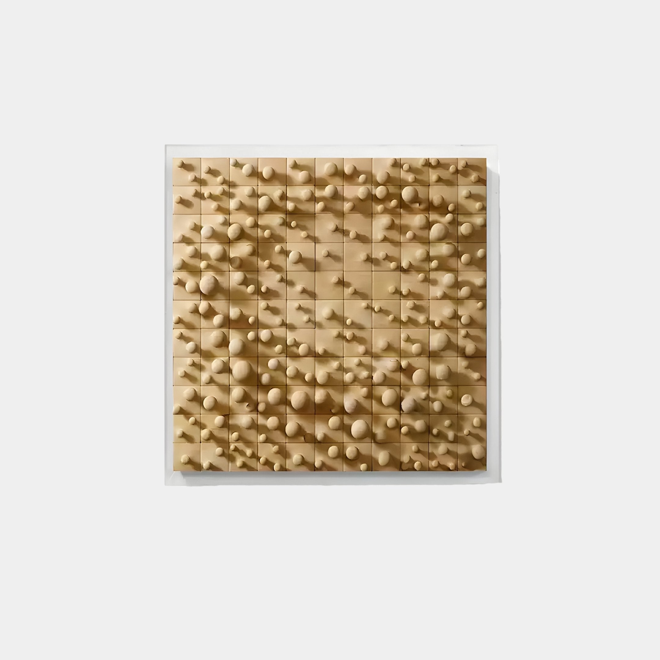 The Orbila Wooden Spheres Dynamic 3D Wall Art by Giant Sculptures features geometric shapes like cones and spheres, artfully protruding from a grid of small square panels against a pristine white background—ideal for contemporary interiors.