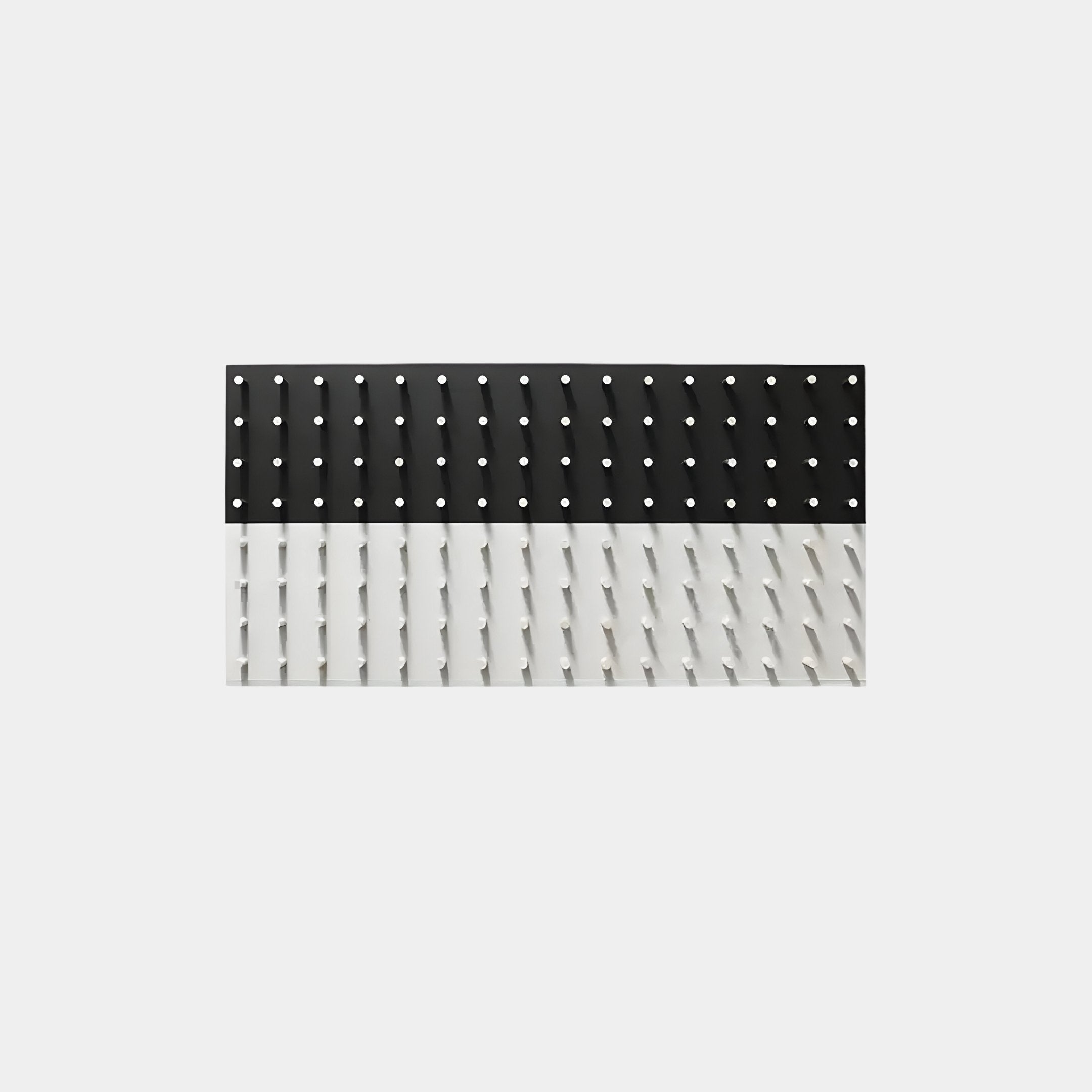 The Contrasto Black & White Linear 3D Wooden Wall Art by Giant Sculptures showcases modern elegance with a black section featuring evenly spaced holes on the top half and a white section with diagonal slits on the bottom half.