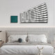 A modern bedroom has a plush bed with patterned pillows and a toy rabbit on the bench. Above hangs the Illustra Teal Highlight BOOM Text 3D Wooden Wall Art by Giant Sculptures, alongside a small teal painting, enhancing the rooms minimalist vibe and subtle geometric design hints.