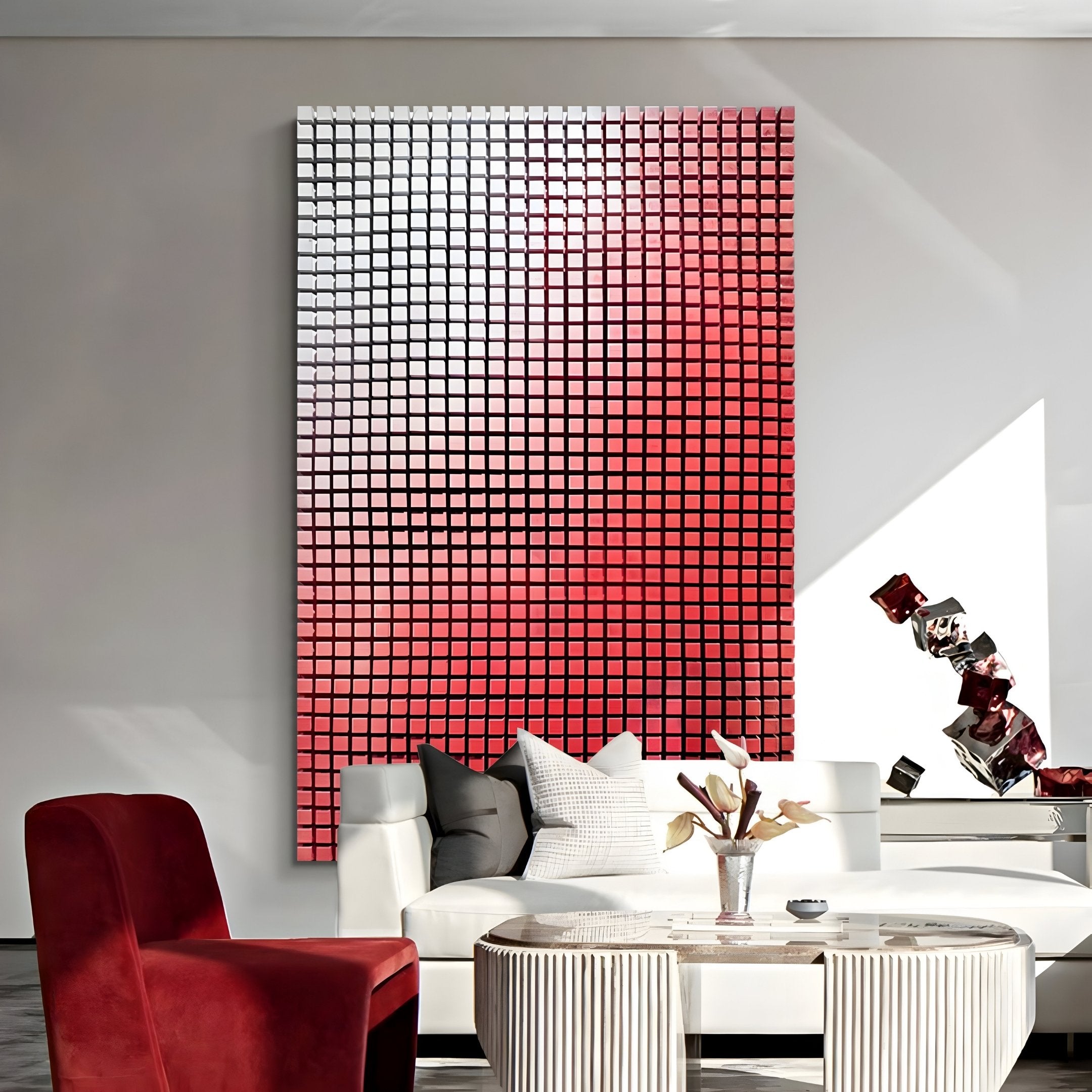 A modern living room showcases the Reflexion Ruby Red Cube Mosaic 3D Wooden Wall Art by Giant Sculptures. The room features a white sofa with pillows, a round coffee table with decorations, and a red chair, all bathed in bright natural light that enhances the vibrant ambiance.