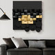 A modern living room showcases a black leather sofa adorned with white and gray cushions. Above it, the Nocturna Black & Gold Modular Wooden Hand-Painted 3D Wall Art by Giant Sculptures hangs, featuring geometric shapes. A sleek black lamp elegantly extends from the left wall.