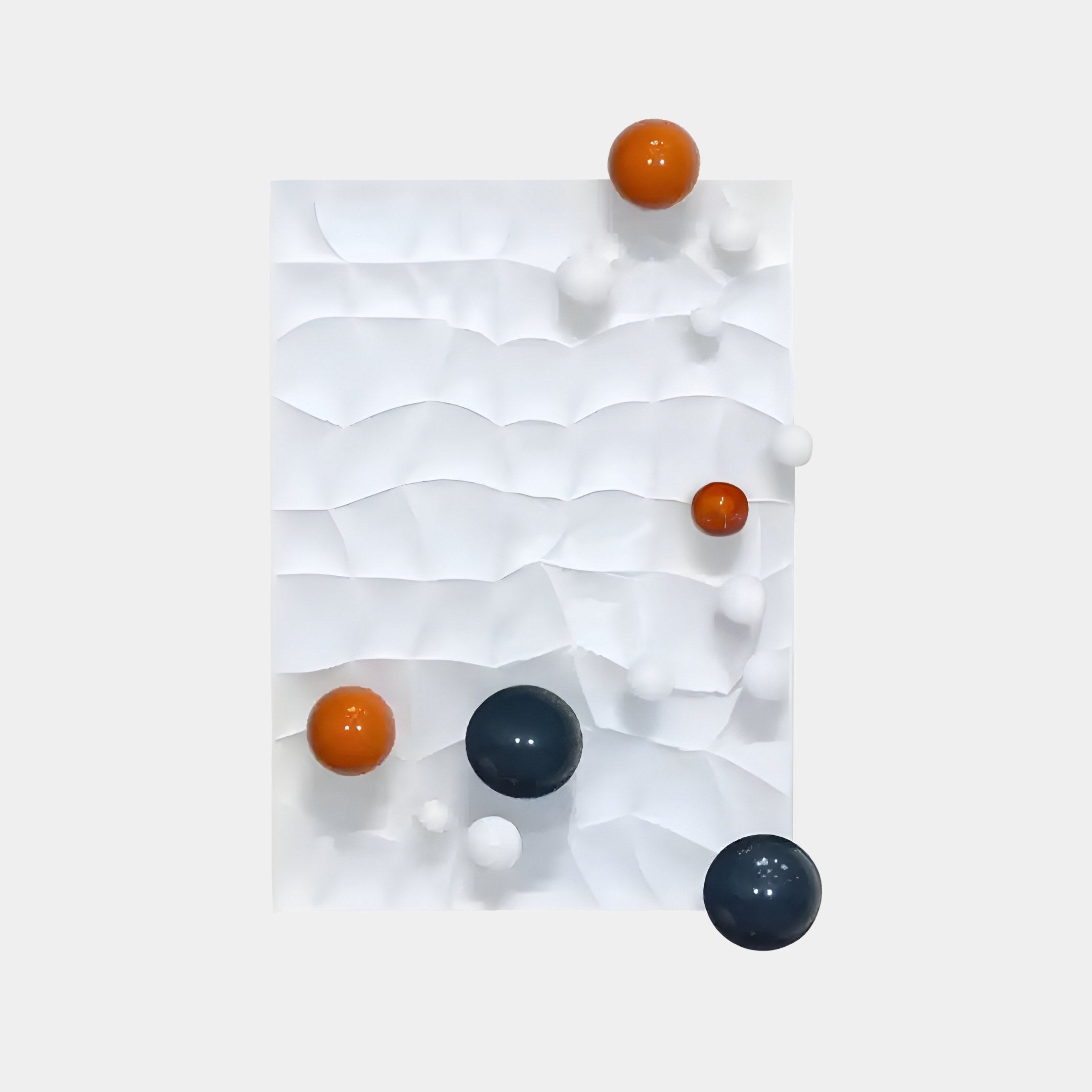 The Orbison White 3D Wood Relief Wall Art With Metal Ball from Giant Sculptures features a textured white rectangular surface with scattered black, orange, and white metal spheres. This minimalist artwork combines wave-like patterns with an abstract design.