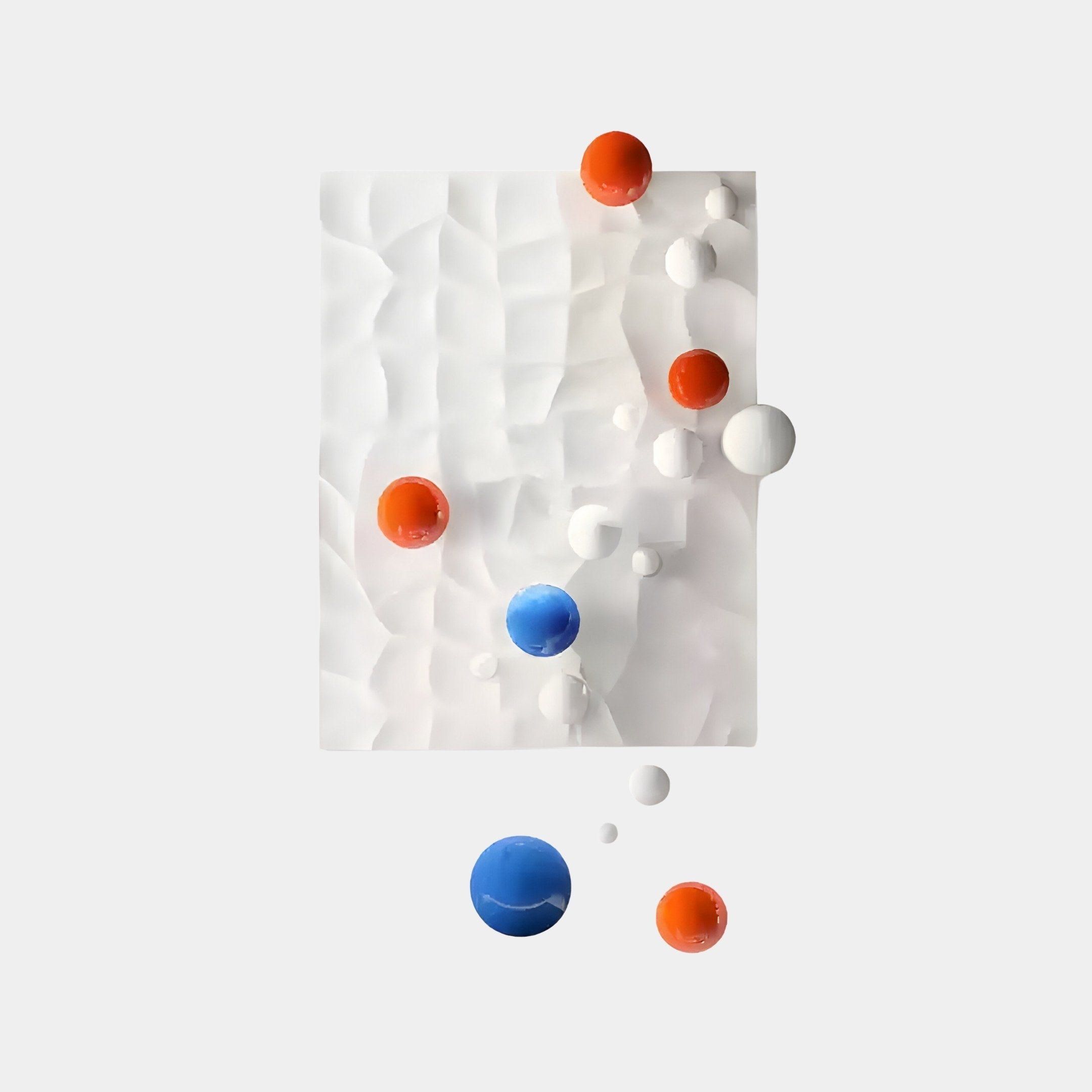 The Orbison White Vertical 3D Wood Relief Wall Art by Giant Sculptures features a textured, translucent rectangular surface with a wave-like pattern. It showcases floating blue, orange, and white metal spheres in varying sizes, dynamically contrasting against the plain gray backdrop.