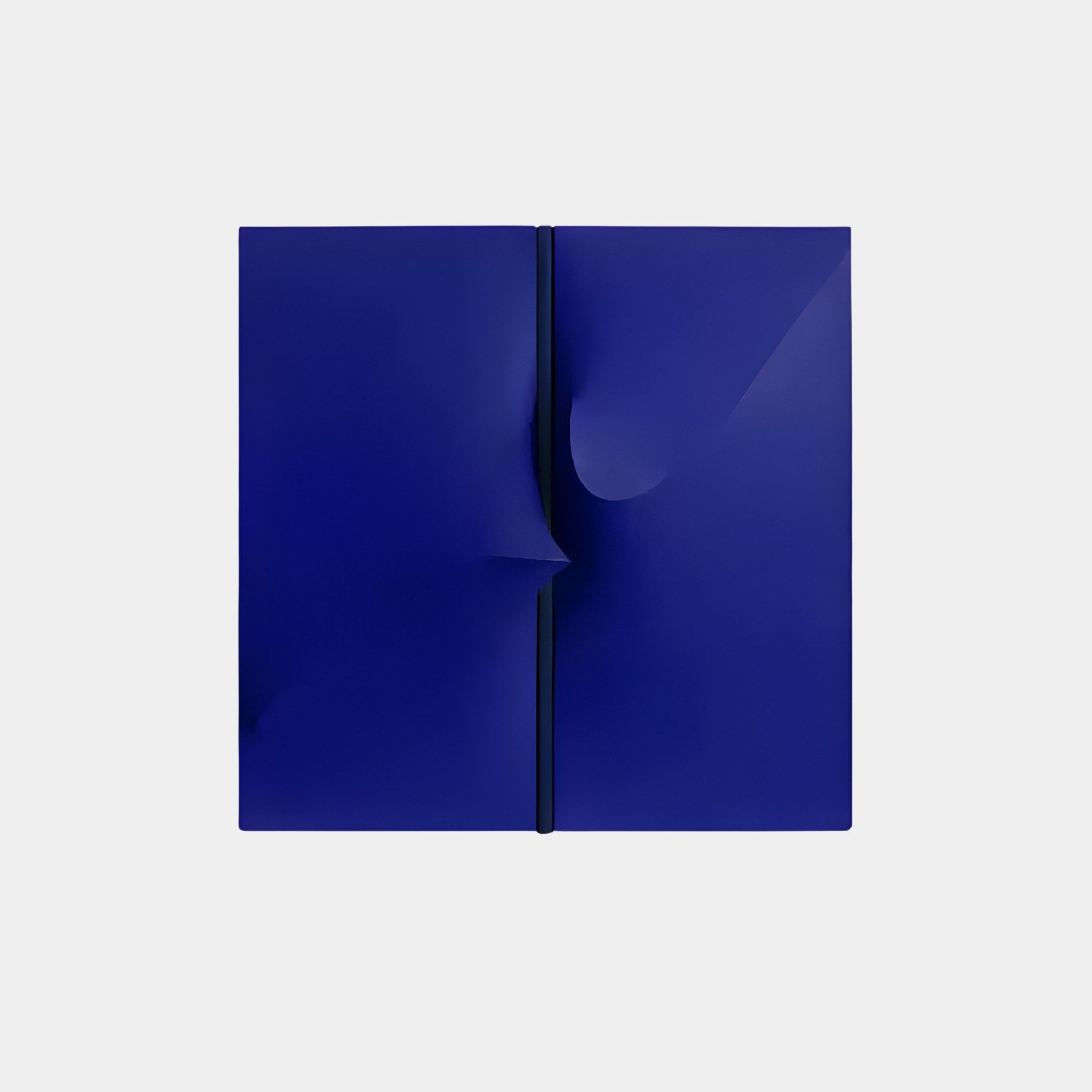 The Delinea Sapphire Blue Stretch Fabric 3D Wood Relief Wall Art by Giant Sculptures features two minimalist sapphire blue panels with a narrow vertical gap. The right panels slightly curled edge creates depth or movement against a light gray background.