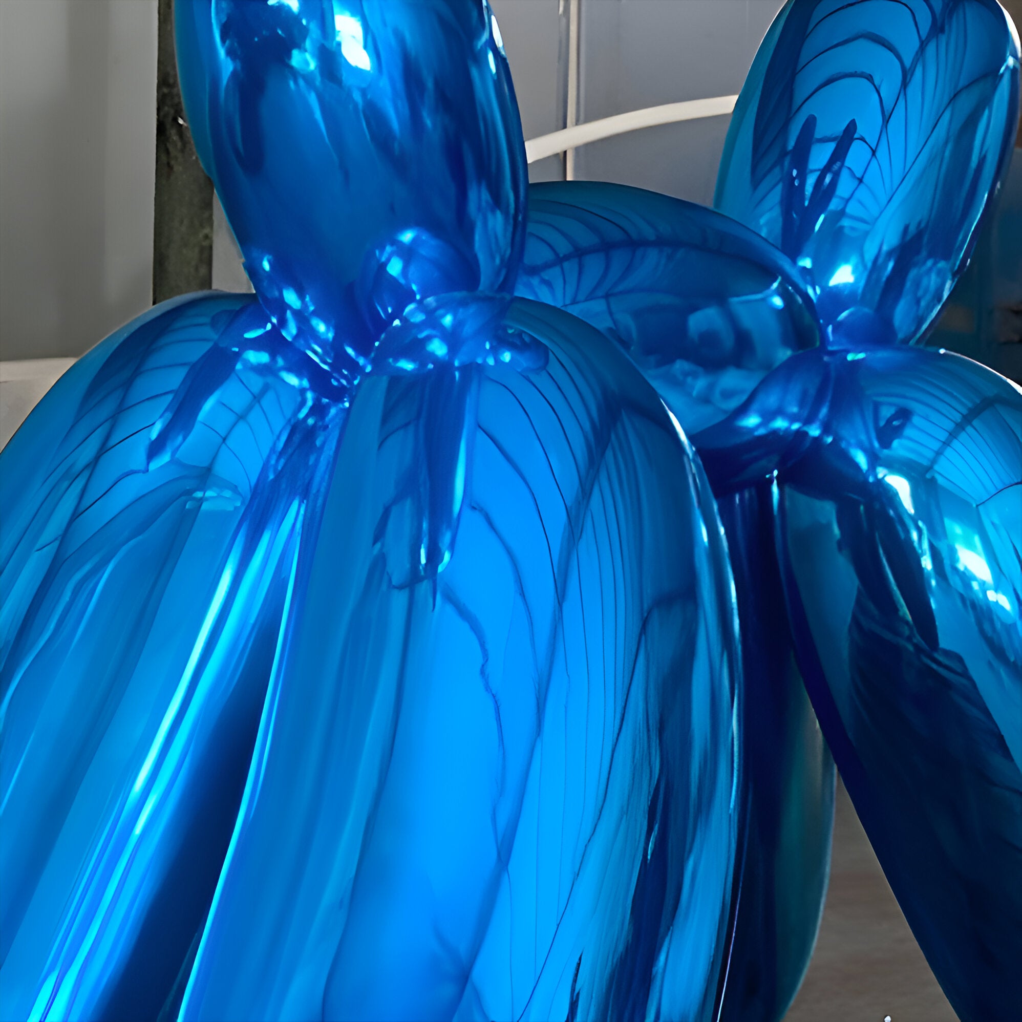 Close-up view of a giant dog sculpture in Sapphire Blue finish, highlighting the intricate reflections and the smooth, mirror-like electroplated surface of the sculpture.