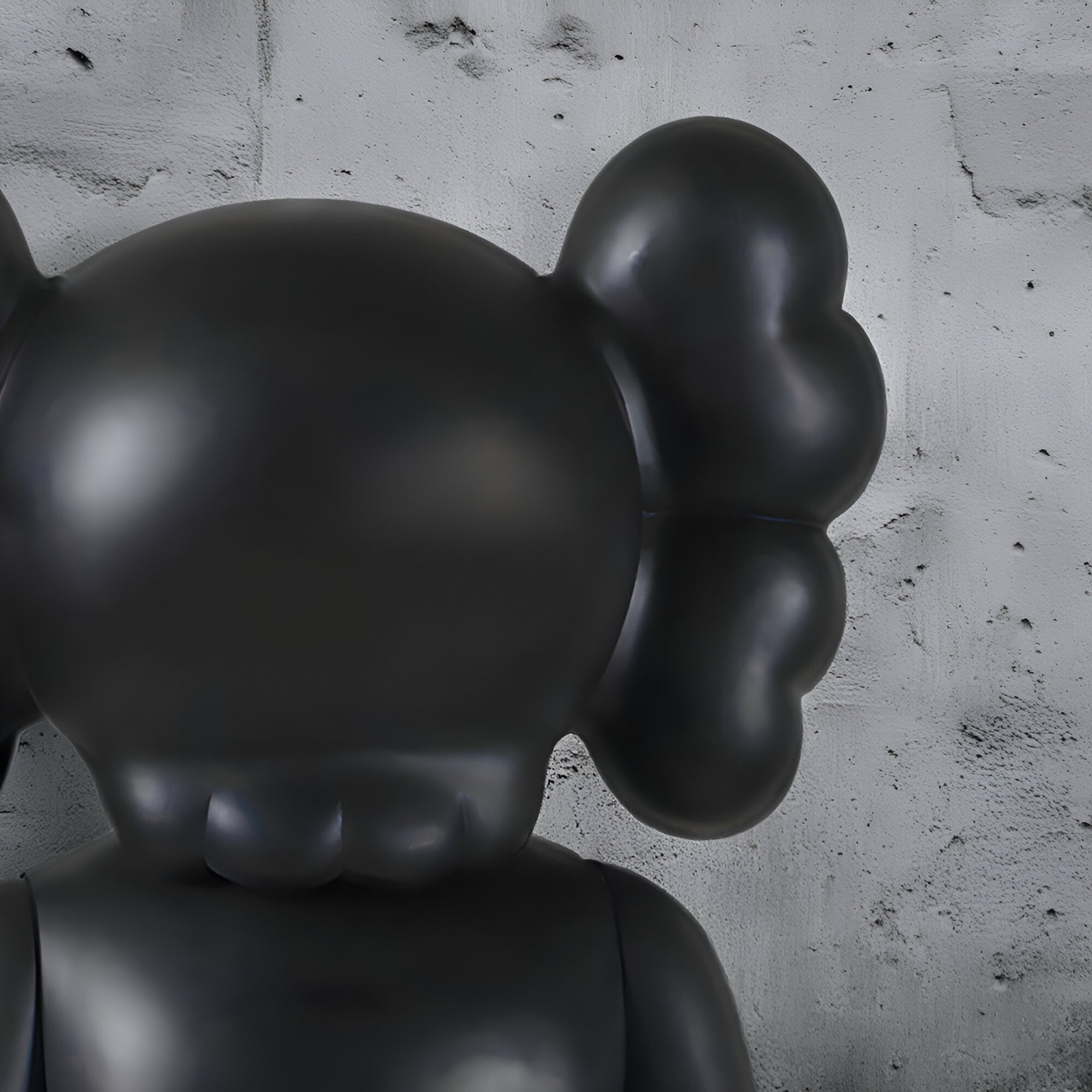 Iconify statue in black close up against concrete wall